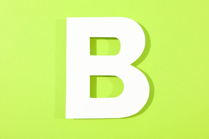 Paper letter B on color background, space for text