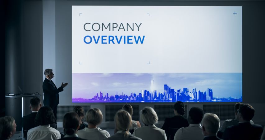 Corporate Event: Male Top Manager Giving Presentation To Colleagues or Investors In Conference Room Of Innovative Startup Office.
