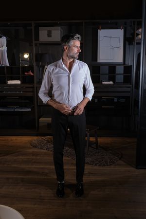 Confident unshaven man in stylish clothes in room