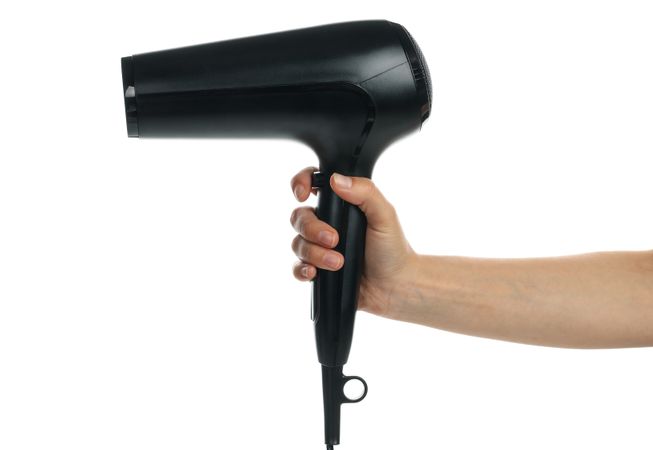 Female hand holds hair dryer, isolated on blank background