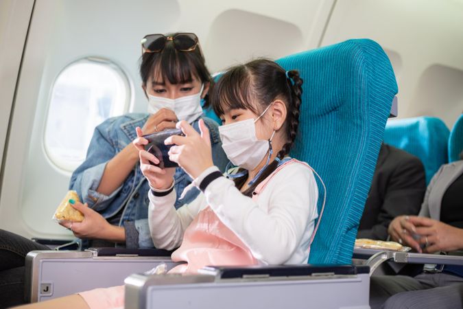 Woman and child sitting together in airplane