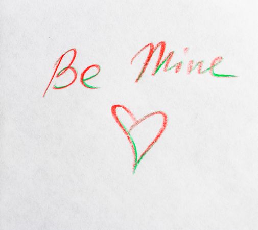 Valentine Day holiday card concept with "Be Mine" and heart written on paper