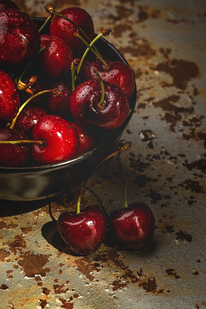 Juicy red cherry in bowl on rustic surface