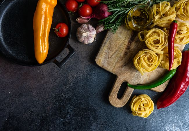 Top view of homemade Fettuccine pasta and ingredients on stone rustic background with copy space