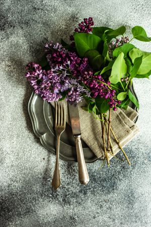 Top view of spring table setting with lilacs on rustic napkin