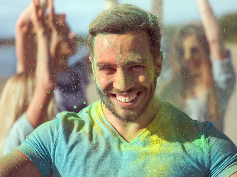 Selfie Portrait of a Muscular Man Celebrating of Holi Festival With His Friends.