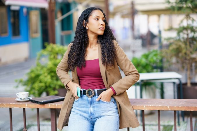 A Stylish Young Woman in a Casual Outfit is Posing Outdoors in a Vibrant Urban Environment