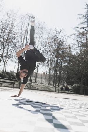 Man dancing break dance in park