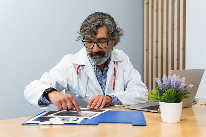 Older doctor using laptop and talking on video call