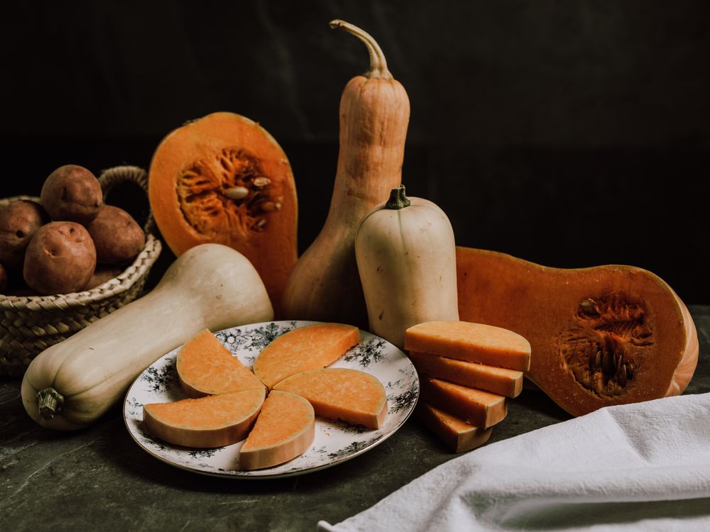 Still life of ripe nutmeg pumpkin and sliced butternut squash