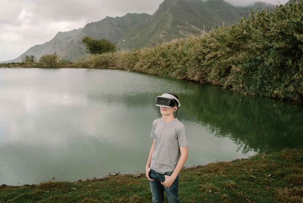 Young teenager with virtual reality glasses outdoors