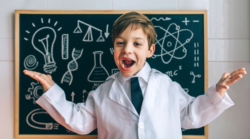 Child dressed as a scientist with chalkboard