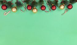 Christmas fir branches plus decorations on green