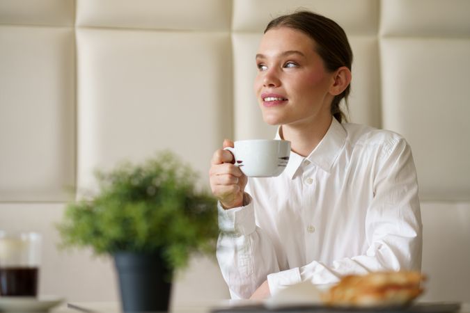 Elegant young businesswoman enjoying morning coffee in a coffee shop
