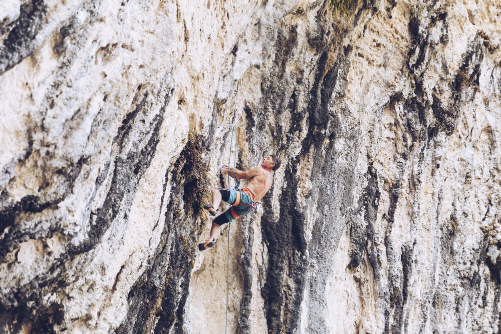 Anonymous man climbing rock