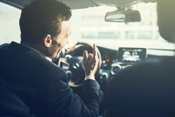 Shot of man driving and talking from the backseat