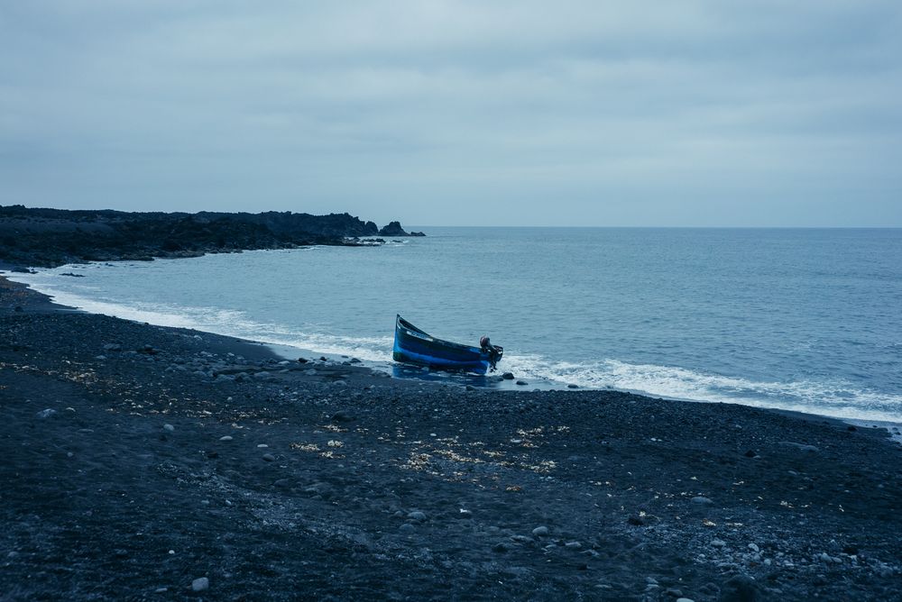 Boat lodged in beach sand on overcast day