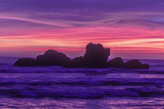 Looking out at rocks in the Pacific Ocean at dusk