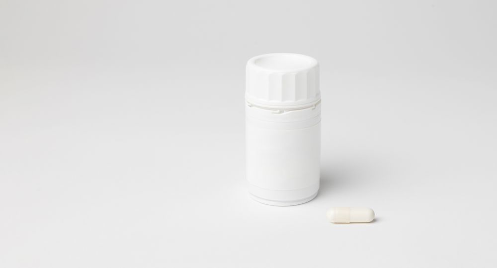 Mockup of a bottle of B12 vitamins in capsules, closed, with copyspace