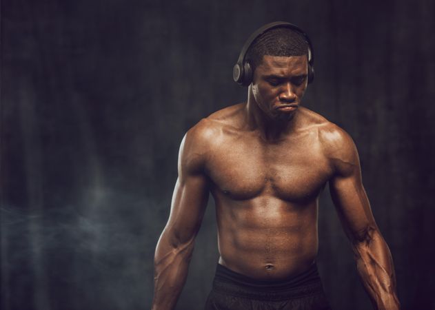Bare chested man listening to music during workout