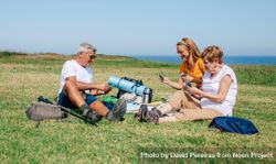 Happy family playing card game during a picnic near the ocean 56pYlb