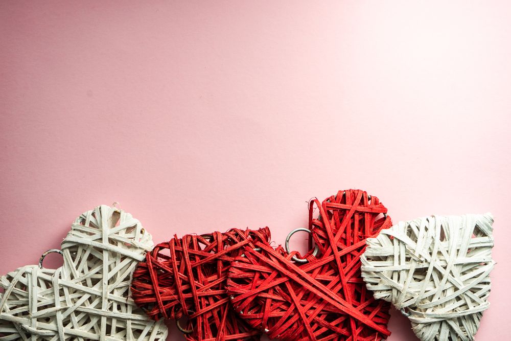 Pink pastel table with thatched red heart ornaments