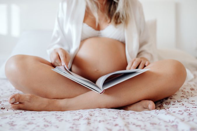 Pregnant woman reading book at home
