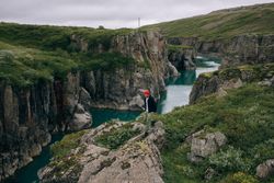 Man hiking on cliff over water