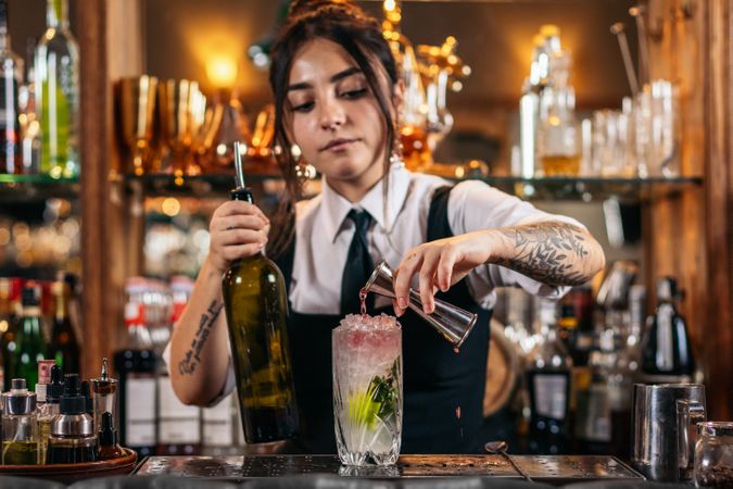 Female bartender preparing a cocktail in a traditional cocktail bar