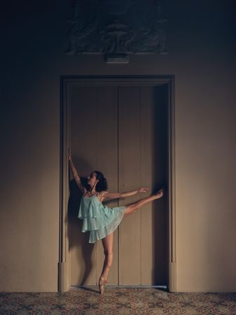 Ballerina standing near room door