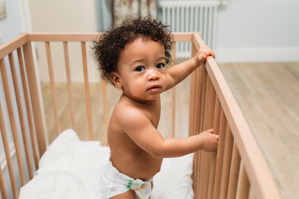 Inquisitive baby boy in crib