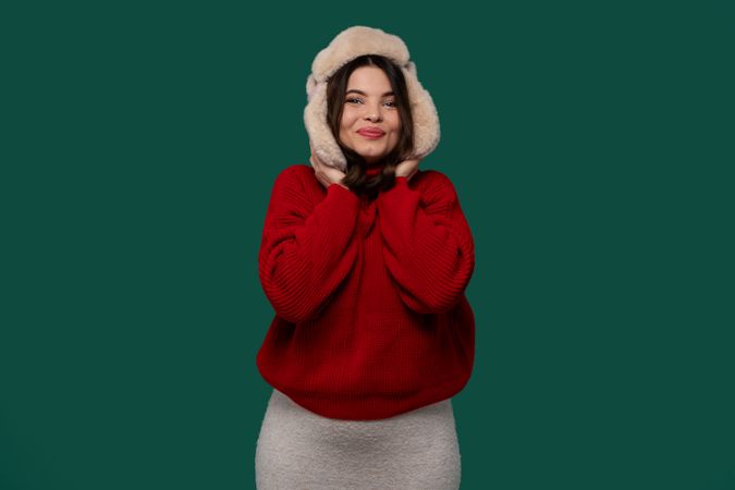Happy woman in red sweater holding fur hat