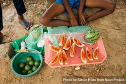 Sri Lankan person at market sitting cross legged in front of freshly cut watermelon 5QZnX4