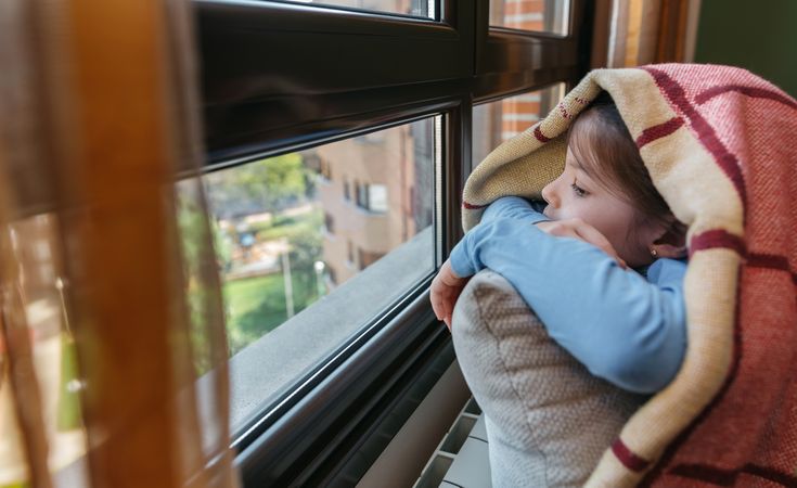 Girl covered with a blanket because she is cold due to economic problems