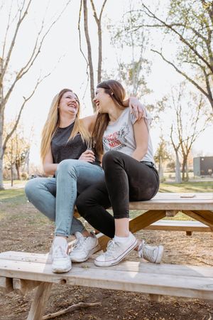 Female friends hugging and laughing in park