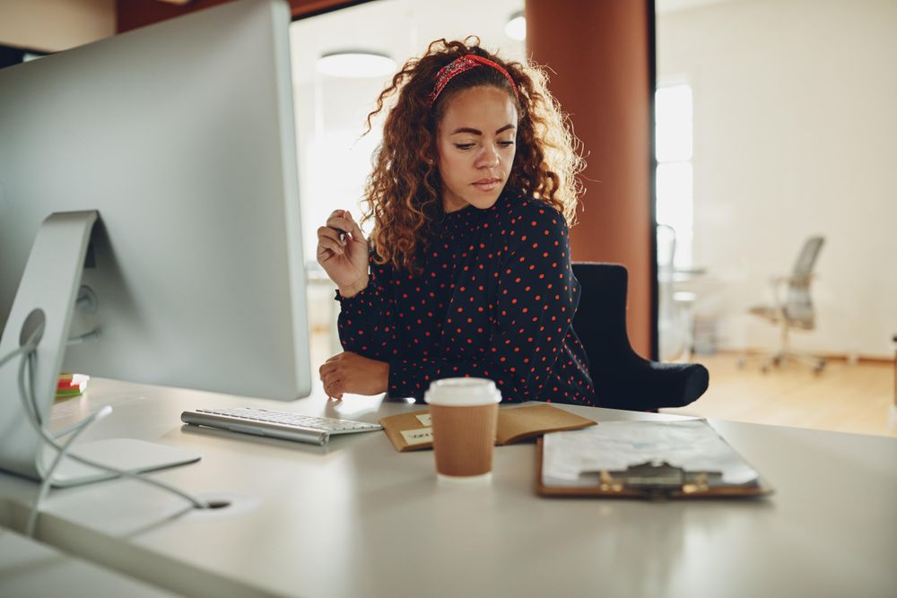 Woman with curly hair at computer at work