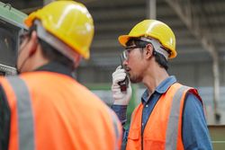 Technician team at construction site in high vis vests & hardhat