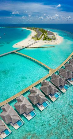 Tall aerial shot of holiday villas at a beach resort in the Maldives