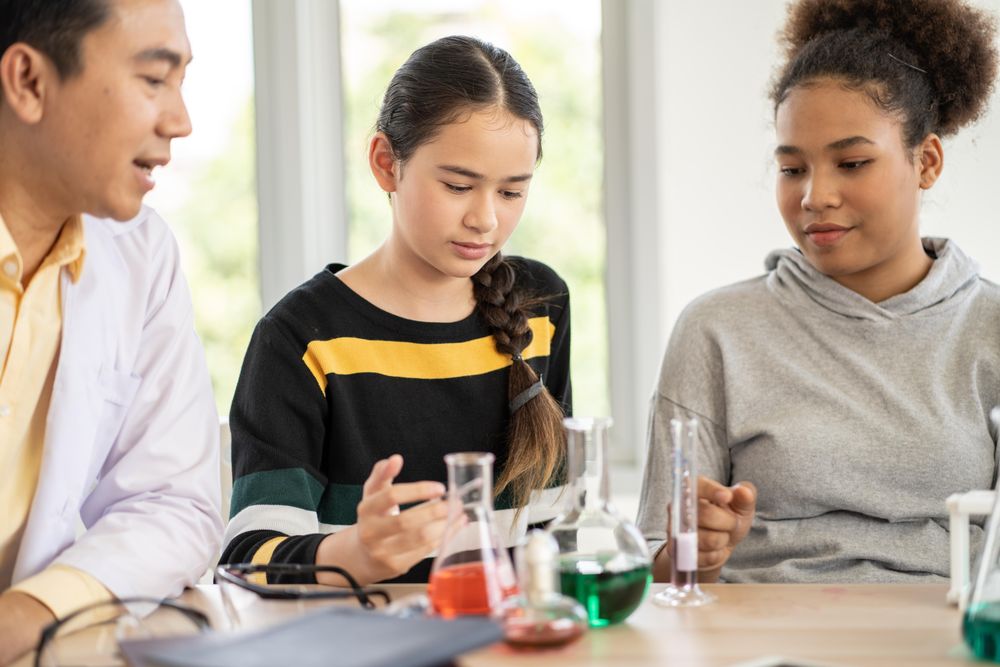 Girls mixing liquids in test tubes and beakers