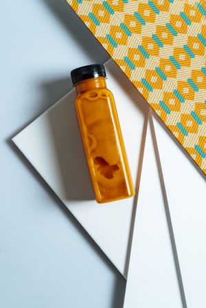Mango and pumpkin smoothie bottle over retro textures