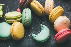 Assortment of multi-colored macaron pastries against a dark background, selective focus, close-up