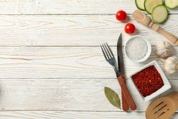 Composition with kitchen cutlery and ingredients for cooking on wooden background, top view