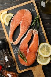 Composition with salmon meat and spices on wooden background, top view