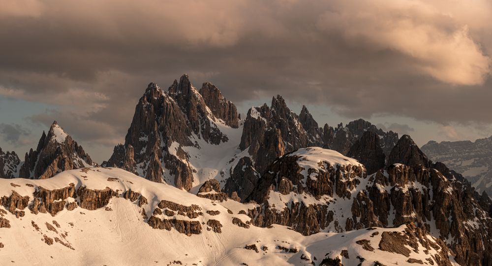 Sharp peaks of rocky mountains against cloudy sky