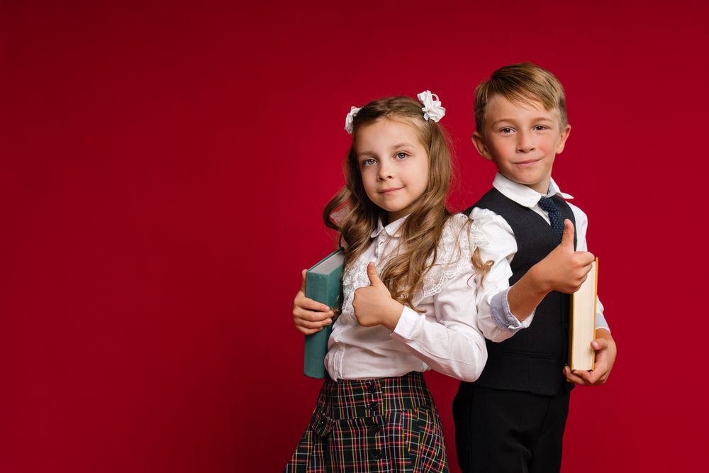 Stylish elementary school students stand with their backs to each other