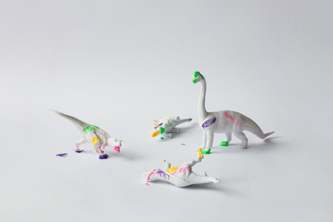 Plastic dinosaurs splattered with different colors of paint