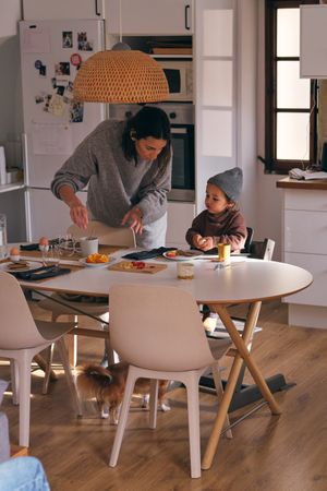 Mother talking to son having breakfast in kitchen