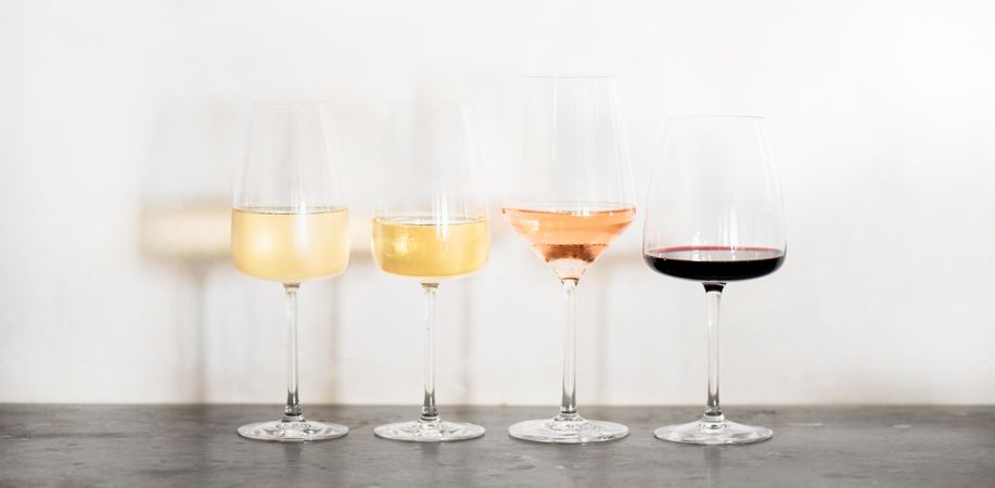 Wine flight of 4 types of wine, from light to dark, in different shaped glassware, wide composition