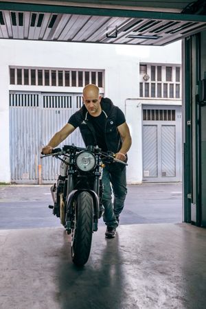 Biker taking motorbike to the garage