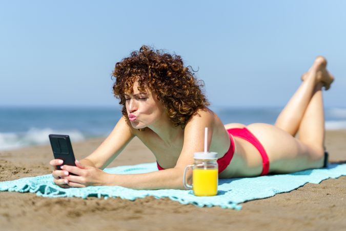 Charming woman taking selfie on coastline